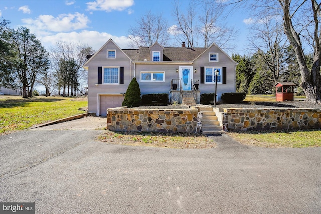 view of front facade with aphalt driveway, a front lawn, a chimney, and a garage