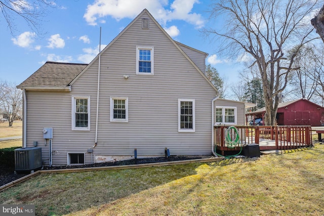 back of house with central air condition unit, roof with shingles, a wooden deck, and a yard