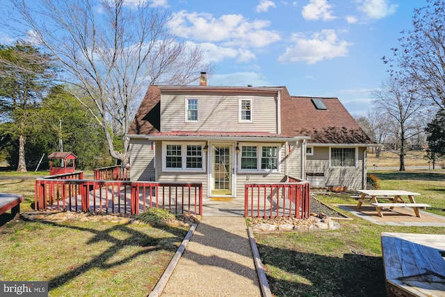 back of property featuring a yard and a chimney