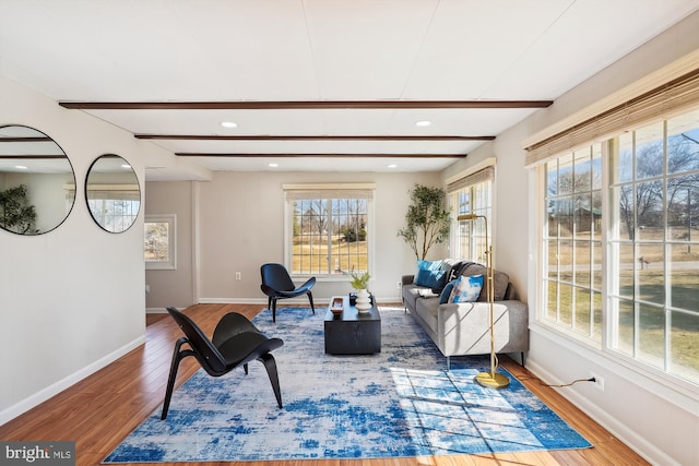 living area featuring recessed lighting, beam ceiling, baseboards, and wood finished floors