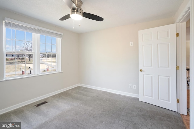 spare room featuring baseboards, visible vents, ceiling fan, and carpet flooring