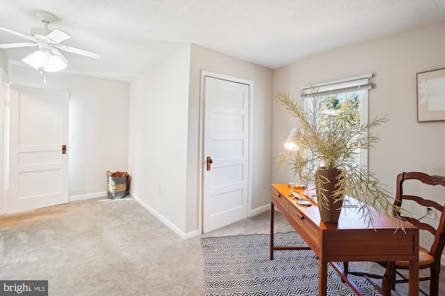 office space featuring light carpet, a textured ceiling, and baseboards