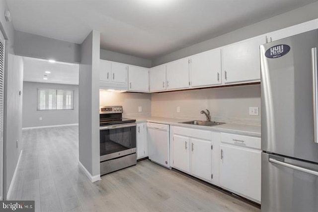 kitchen with sink, white cabinetry, light hardwood / wood-style floors, and appliances with stainless steel finishes