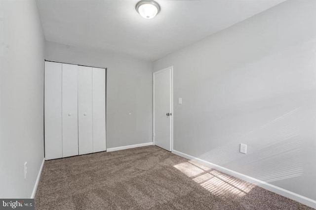 unfurnished bedroom with a closet and carpet flooring