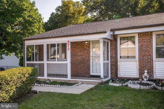 view of front facade featuring a front yard and a sunroom