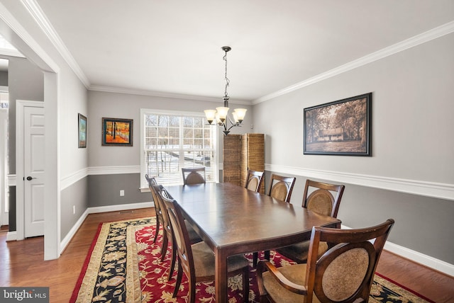 dining room featuring wood-type flooring, an inviting chandelier, and ornamental molding