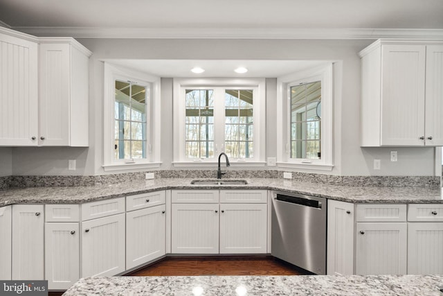 kitchen with dishwasher, light stone counters, white cabinetry, and sink