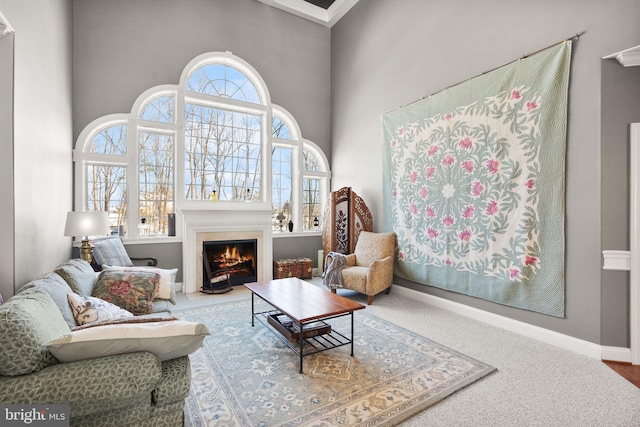 carpeted living room with plenty of natural light and a high ceiling