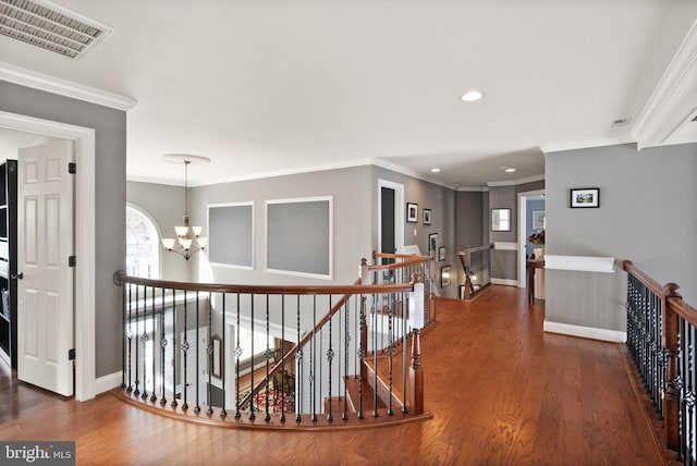 corridor with crown molding, dark wood-type flooring, and a notable chandelier