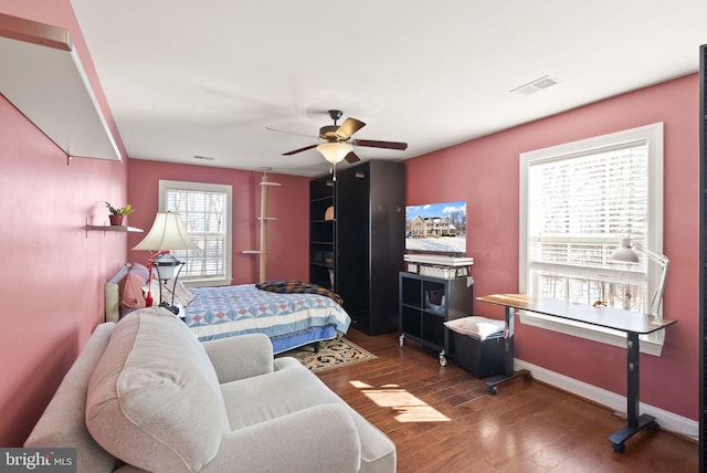 bedroom featuring multiple windows, ceiling fan, and wood-type flooring