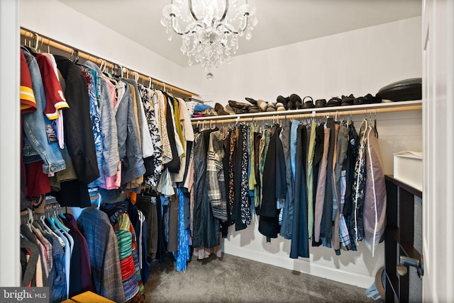 walk in closet featuring a notable chandelier and carpet floors