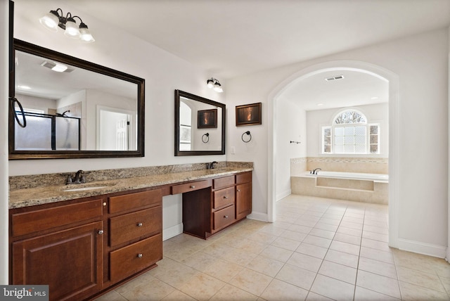 bathroom featuring tile patterned floors, vanity, and shower with separate bathtub