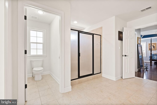 bathroom with toilet, tile patterned flooring, and walk in shower