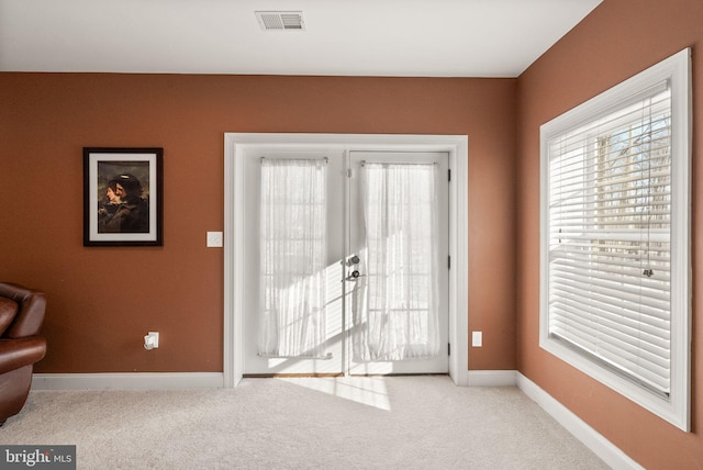 entryway featuring french doors and light colored carpet