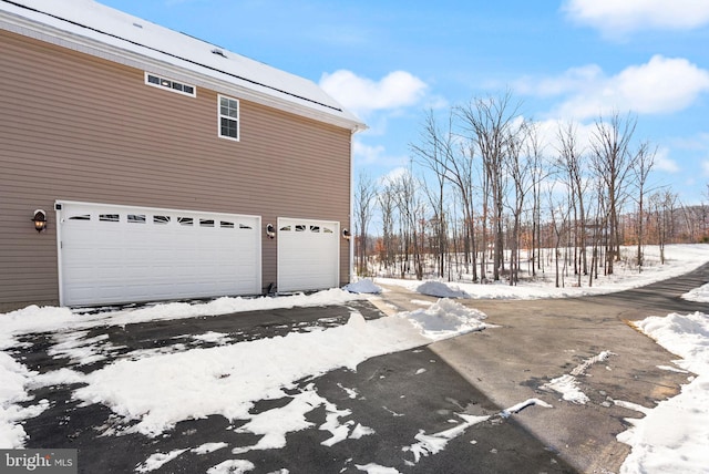 view of snow covered exterior featuring a garage