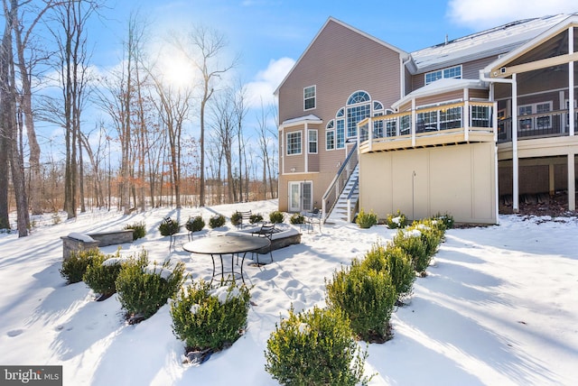 snow covered property with a sunroom