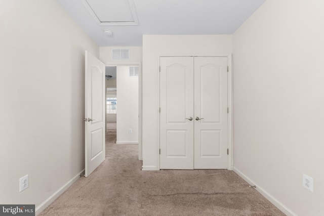 unfurnished bedroom with light carpet and a closet