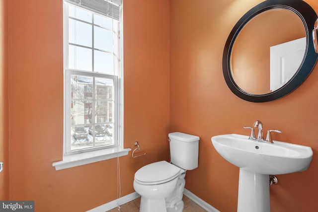 bathroom with toilet, tile patterned floors, and sink