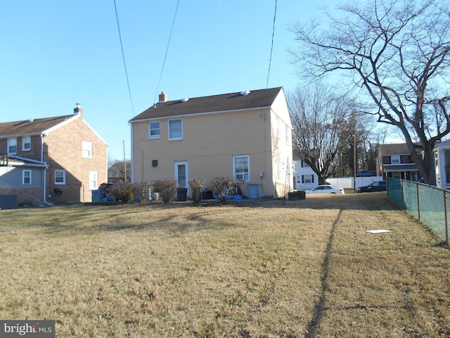 back of house featuring a lawn