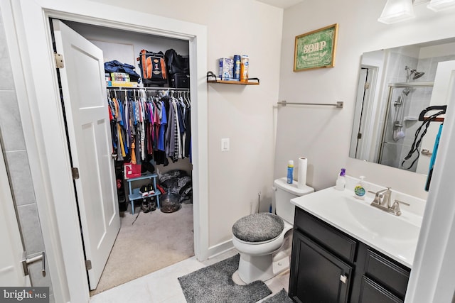 bathroom with tile patterned floors, vanity, an enclosed shower, and toilet