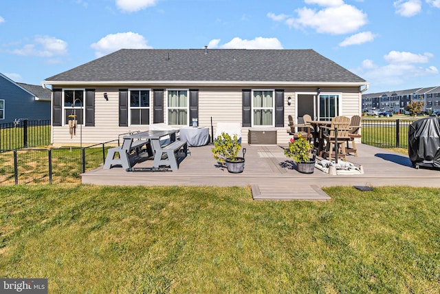 rear view of property featuring a yard and a deck