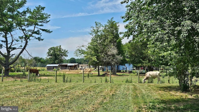 view of yard featuring a rural view and an outbuilding