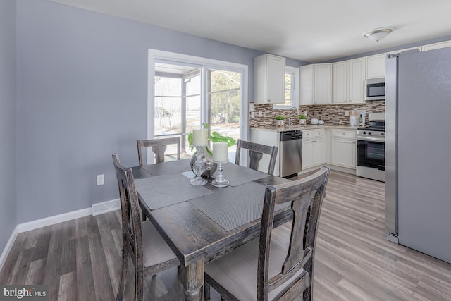 dining room featuring light wood-type flooring and sink