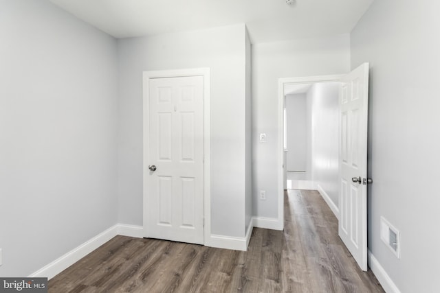 unfurnished bedroom featuring dark wood-type flooring and a closet