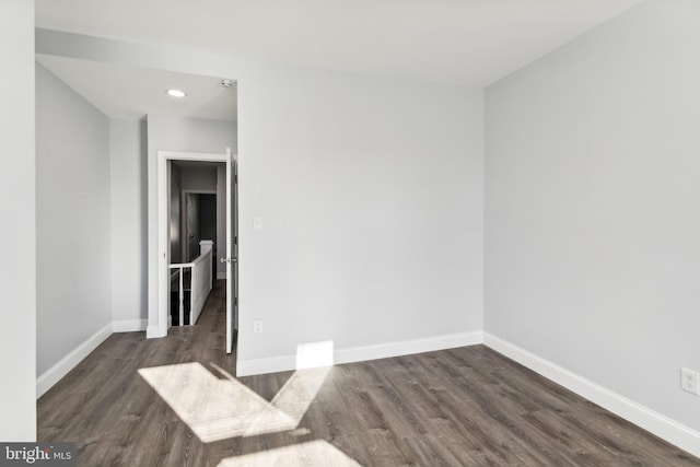 empty room with dark hardwood / wood-style flooring