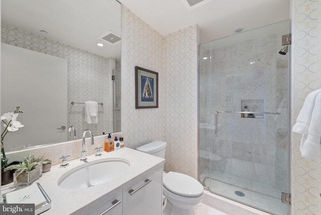 bathroom featuring vanity, toilet, and an enclosed shower