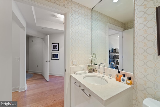 bathroom featuring wood-type flooring, vanity, and toilet