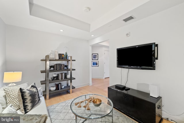 living room featuring a tray ceiling and hardwood / wood-style floors