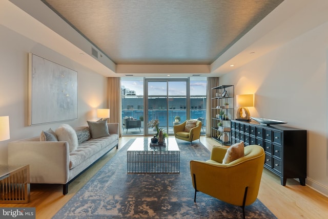 living room with wood-type flooring and a wall of windows