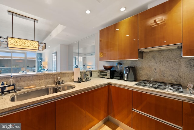 kitchen featuring extractor fan, sink, decorative backsplash, light stone countertops, and stainless steel gas cooktop