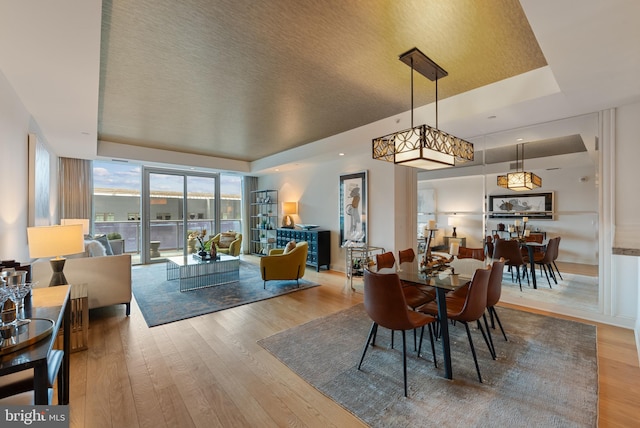 dining area with a raised ceiling and hardwood / wood-style flooring