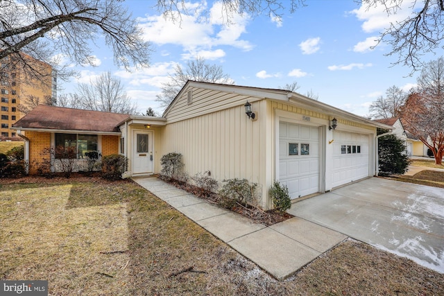 exterior space featuring an attached garage, a front lawn, concrete driveway, and brick siding