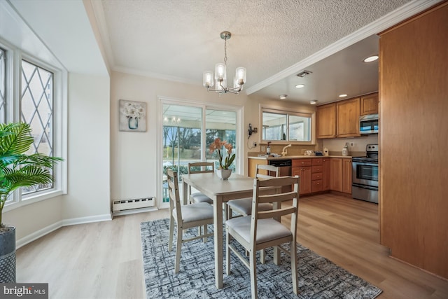 dining room featuring light wood-type flooring, a baseboard radiator, crown molding, and a textured ceiling