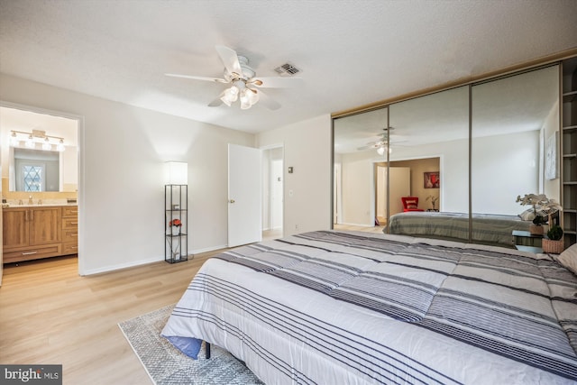 bedroom featuring visible vents, a closet, light wood-style flooring, and baseboards