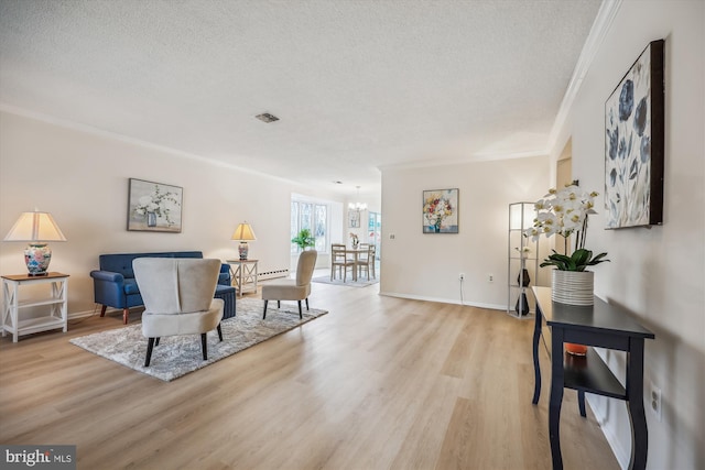 living area with visible vents, a notable chandelier, a textured ceiling, and light wood finished floors