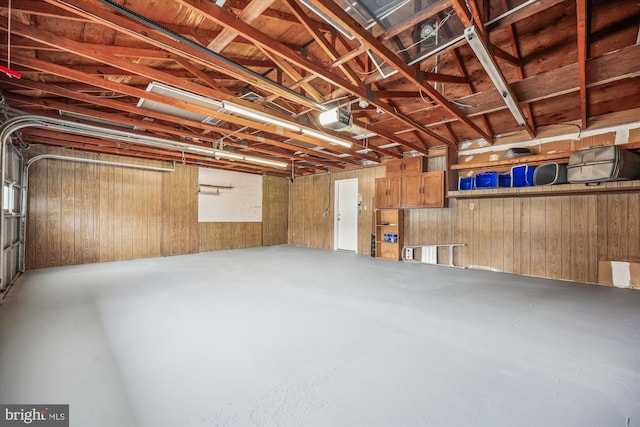 garage featuring a garage door opener and wood walls