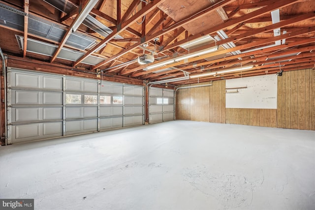 garage with a garage door opener and wooden walls