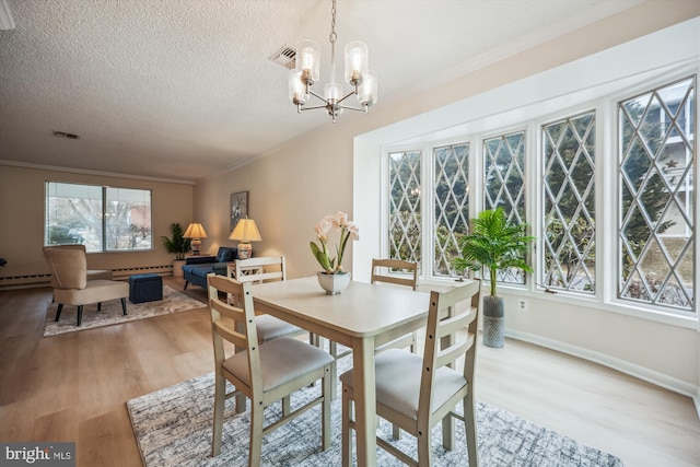 dining area with crown molding, visible vents, light wood-style flooring, an inviting chandelier, and a textured ceiling