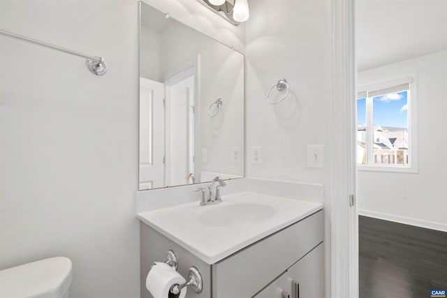 bathroom with toilet, wood-type flooring, and vanity