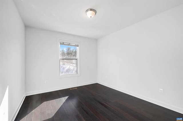 unfurnished room with dark wood-type flooring