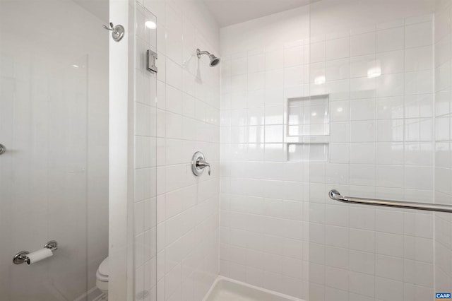 bathroom with toilet and tiled shower