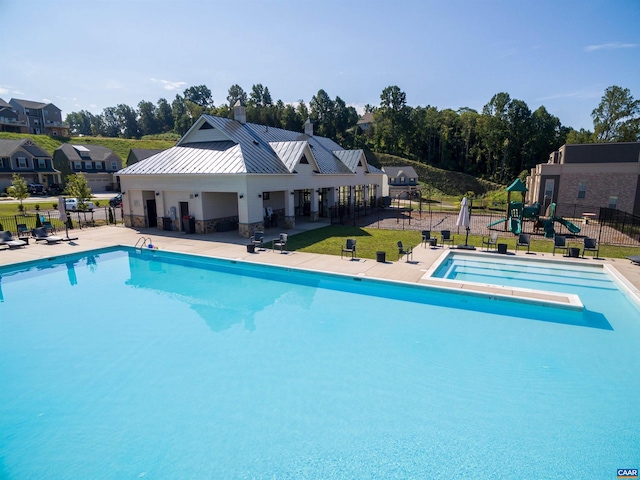 view of swimming pool with a playground, a diving board, and a patio area