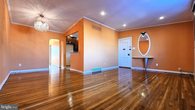 unfurnished room featuring dark hardwood / wood-style flooring, an inviting chandelier, and ornamental molding