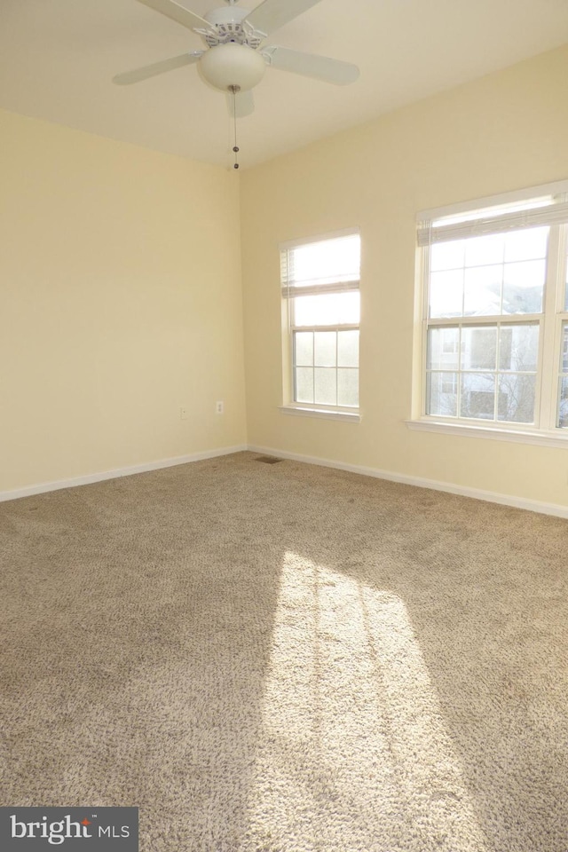 carpeted spare room featuring ceiling fan