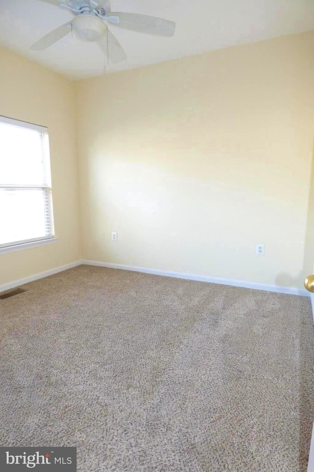 carpeted spare room with ceiling fan