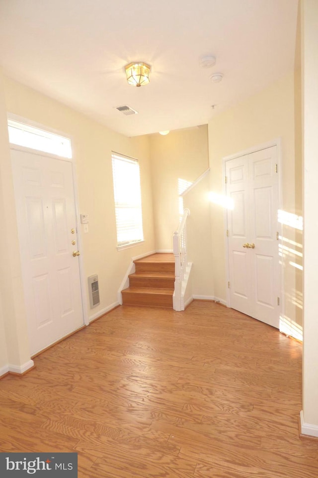 foyer with hardwood / wood-style flooring and heating unit